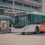 Ônibus urbano parado em um ponto enquanto passageiros embarcam.
