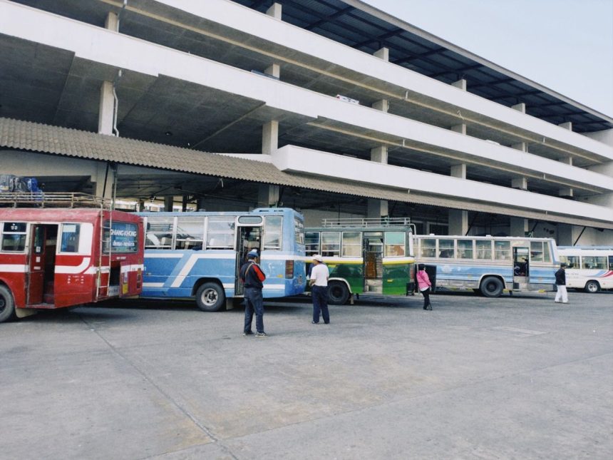 Terminal rodoviário urbano com vários ônibus coloridos estacionados.
