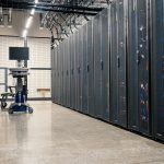Gabinetes com servidores, equipamentos de rede e cabos em um data center moderno