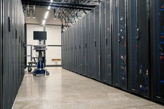 Gabinetes com servidores, equipamentos de rede e cabos em um data center moderno