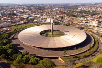 Vista aérea do terminal rodoviário de Londrina, com ônibus e a área urbana ao fundo